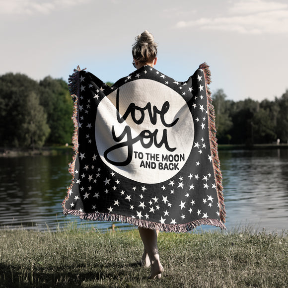 Love you to the Moon and Back phrase on soft black and natural white stars and moon celestial woven cotton blanket