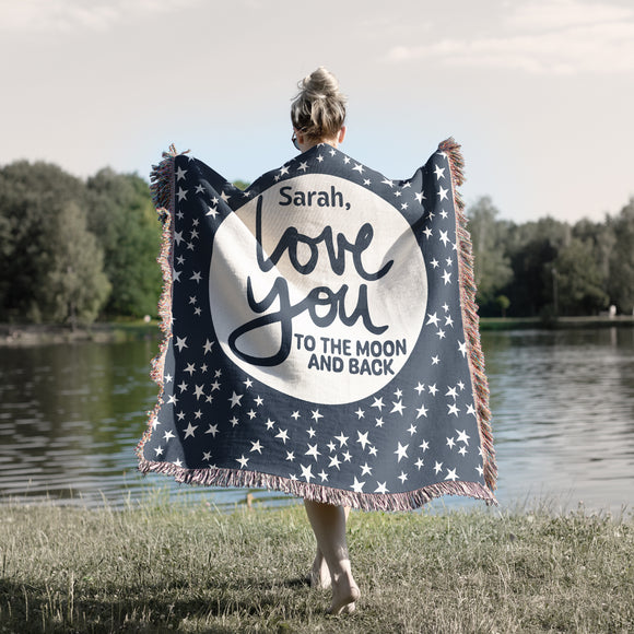 Personalized Love you to the Moon and Back phrase on soft navy blue and natural white stars and moon celestial woven cotton blanket. Personalized with First name. Made in the USA